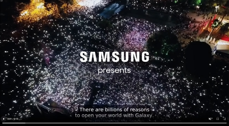 Luftaufnahme eines nächtlichen Konzerts mit tausenden leuchtenden Smartphone-Lichtern und der Einblendung „SAMSUNG presents