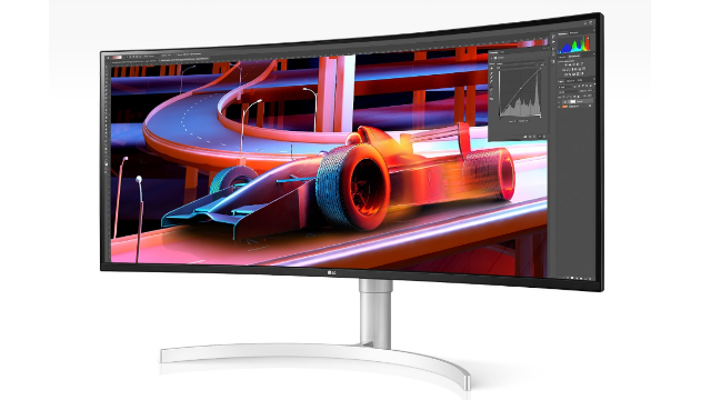 Ein gekrümmter Monitor auf einem weißen Hintergrund zeigt ein Formel-1-Rennen auf einer Strecke mit orangefarbenen Geländern.