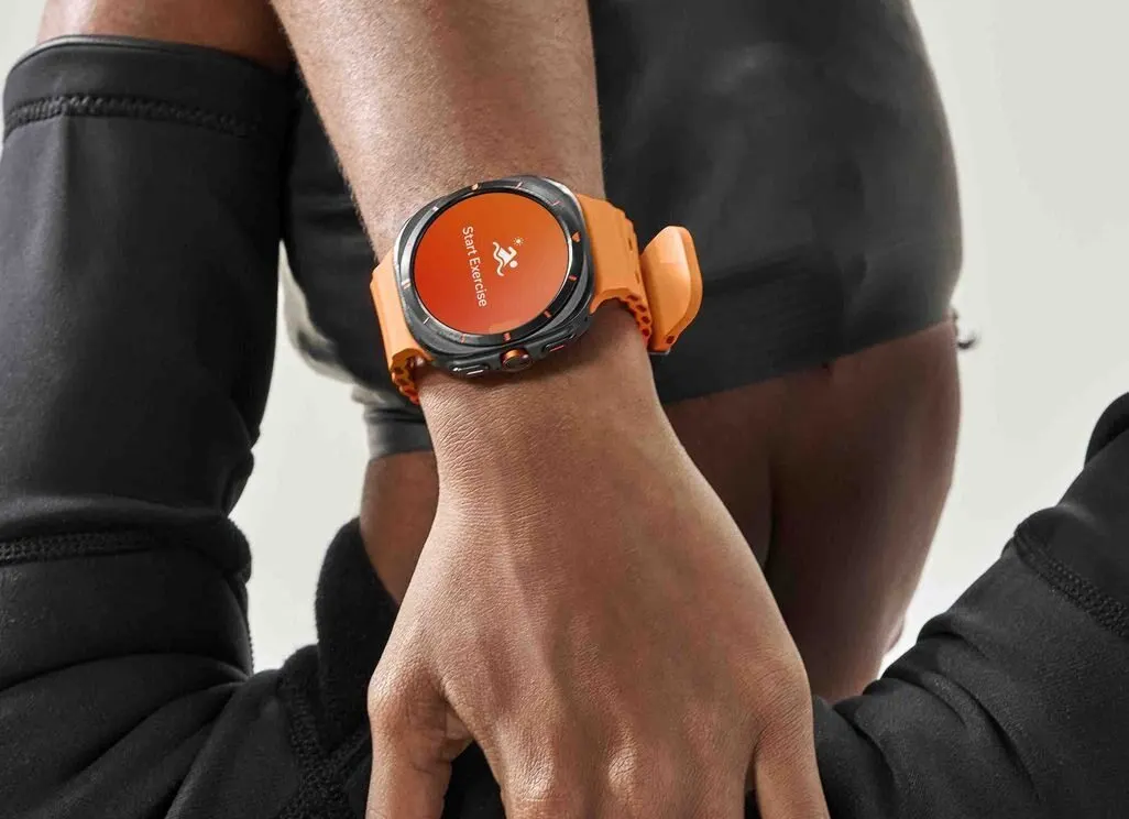 Person traegt eine Smartwatch mit orangefarbenem Armband und startet ein Training