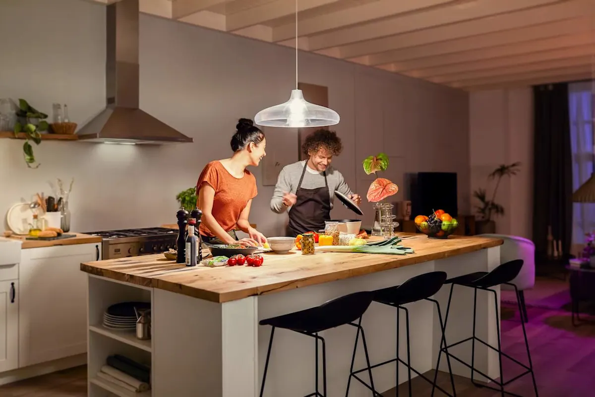 Eine Frau und ein Mann kochen in einer Küche mit heller Beleuchtung.