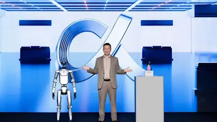 James Li, CEO von Honor, mit einem humanoiden Roboter und dem Robot Phone an seiner Seite. Im Hintergrund wird ein Alpha-Zeichen eingeblendet.