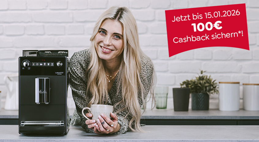 Eine schwarze Kaffeemaschine steht auf einer Theke, daneben eine Frau mit einer Tasse in der Hand und einer Werbeanzeige mit "100€ Cashback. Jetzt bis 15.1.20266".