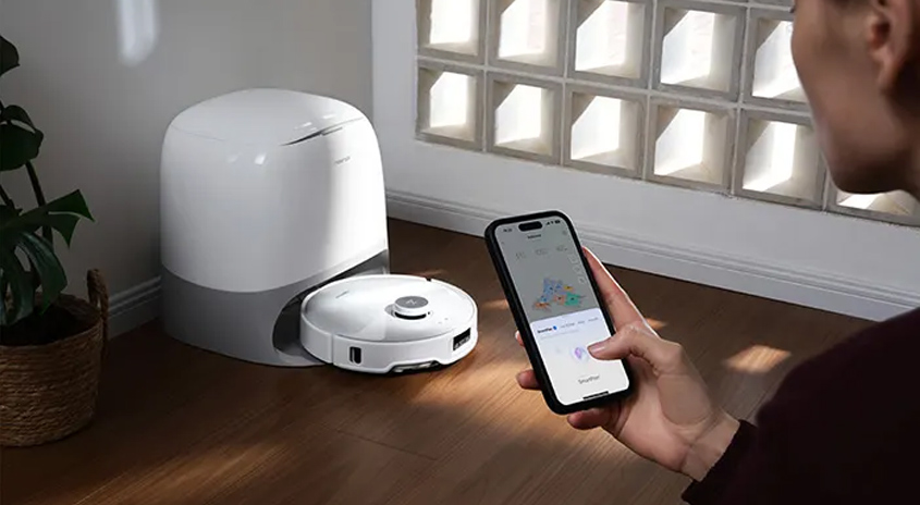 Ein Mann pogrammiert auf seinem Smartphone die App für den Roborock