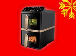 Airfryer auf rotem Hintergrund, dekoriert mit gelber Schneeflocke in der Ecke.