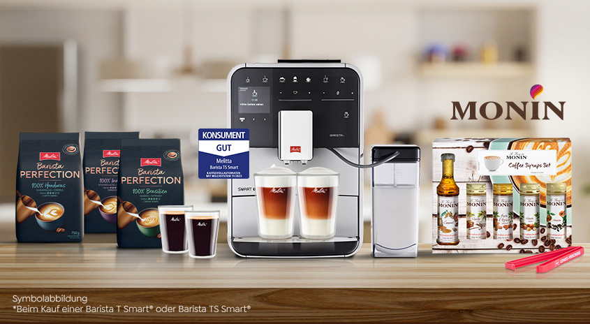 Eine Kaffeemaschine mit Kaffeebohnen, Sirup und Tassen auf einem Tisch vor einem Küchenhintergrund.