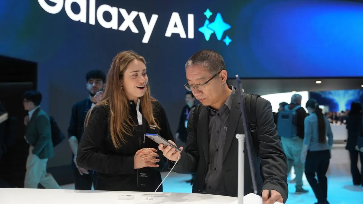 2 Personen betrachten ein Smartphone am Samsung Galaxy AI Stand auf einer Technikmesse