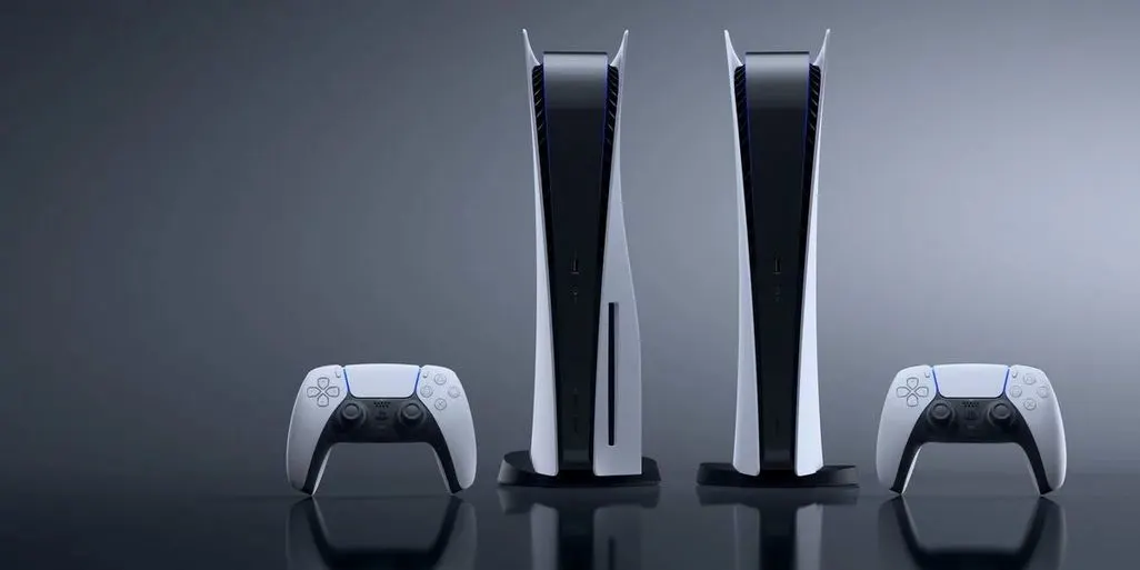 Zwei PlayStation 5 Konsolen stehen aufrecht nebeneinander, daneben jeweils ein weißer Controller.