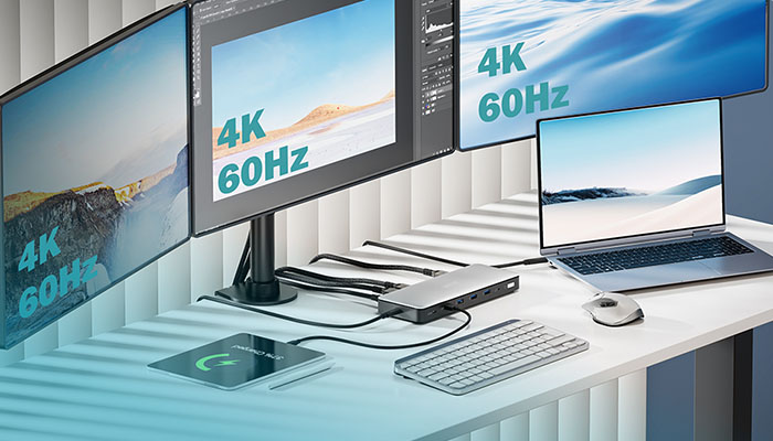 Ein moderner Arbeitsplatz mit einer vielseitigen Digitus Dockingstation in der Mitte. Sie verbindet einen Laptop per Kabel mit drei großen externen Monitoren, die gestochen scharfe Bilder in "4K 60Hz" anzeigen. Auf dem aufgeräumten weißen Schreibtisch befinden sich zudem Tastatur, Maus und ein ladendes Tablet.