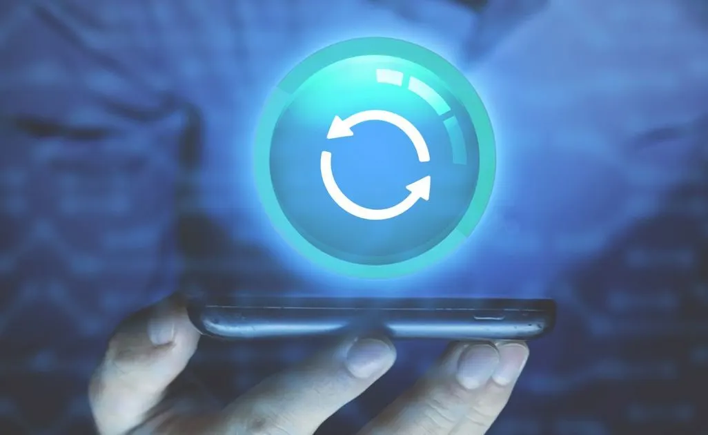 Symbol für Synchronisation schwebt über einem Smartphone in einer Hand.