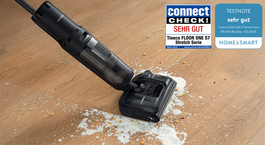 Tineco FLOOR ONE S7 Stretch saugt und wischt Milch und Krümel von einem Holzboden; daneben zwei Testsiegel mit der Bewertung „sehr gut“ von connect und home&smart.