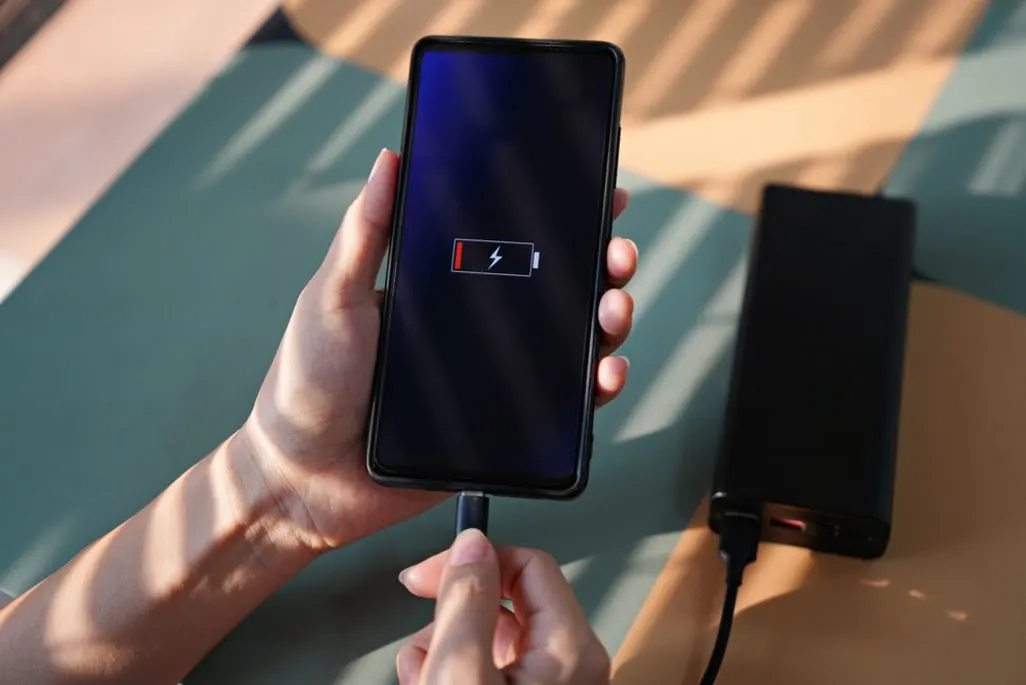 Smartphone mit niedrigem Akkustand wird an an eine Powerbank angeschlossen.