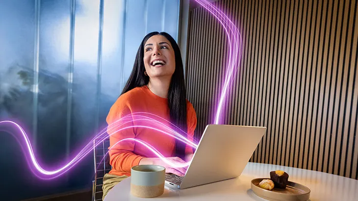 Frau im orangefarbenen Pullover lächelt am Laptop; leuchtende violette Linien symbolisieren digitale Energie und Vernetzung.