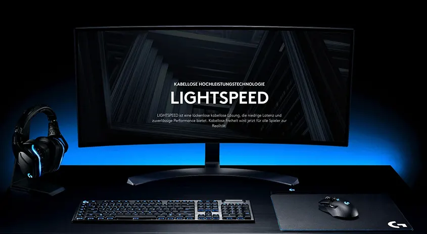 Ein Gaming-Setup mit einem Monitor, einer Tastatur, einer Maus, einem Mauspad und einem Headset, alle in Schwarz. Der Monitor zeigt den Text "LIGHTSPEED".