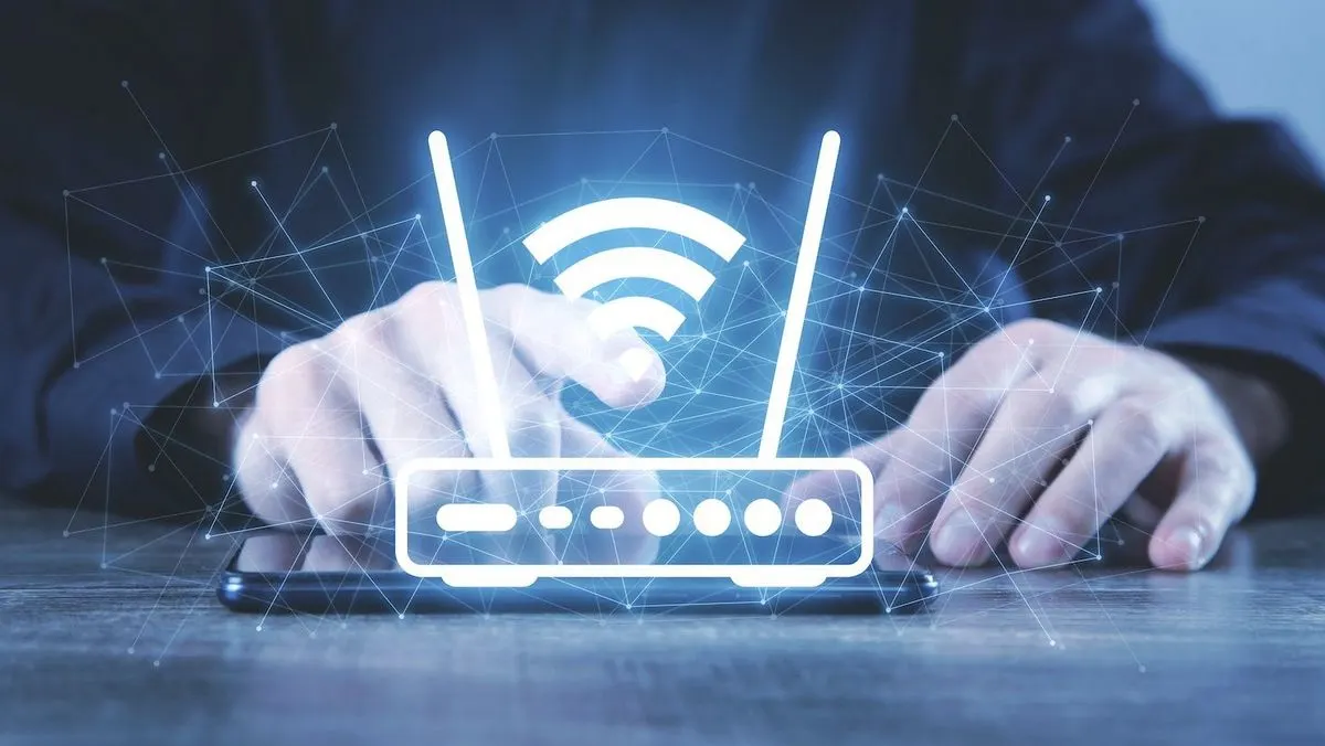 Hände über einem Smartphone mit einem leuchtenden weißen WLAN-Router-Symbol und Signalwellen mit blauem Netzwerk-Hintergrund.