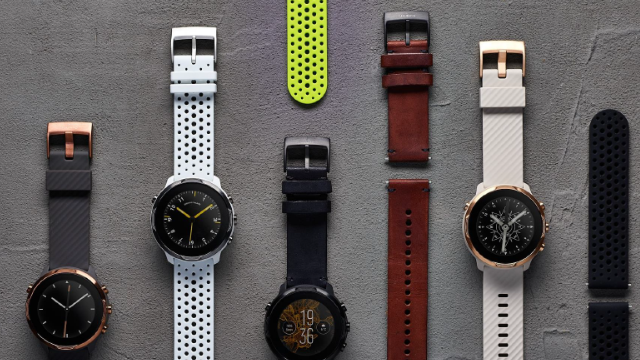 Auf grauem Grund liegen Uhren und Armbänder in Schwarz, Weiß, Braun und Gelb.