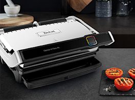 Tefal Griller davor liegen auf einem Brett drei halbe, gegrillte Tomaten