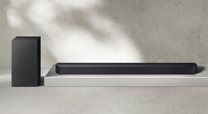 Schwarze Soundbar und Subwoofer vor dunklem Hintergrund. Soundbar rechteckig, Subwoofer Würfel.