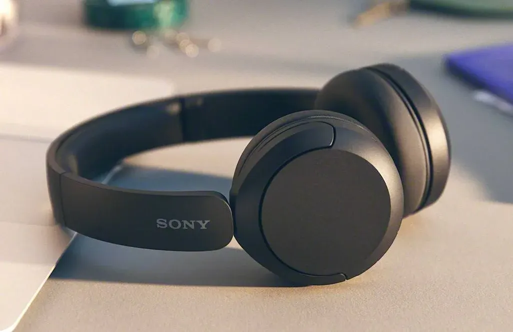 Schwarze Sony-Kopfhörer mit Over-Ear-Design auf einem weißen Schreibtisch, mit natürlicher Beleuchtung