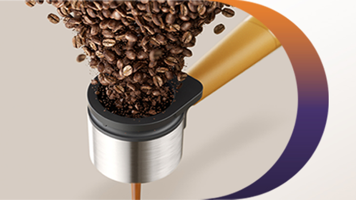  Nahaufnahme frischer Kaffeebohnen, die in einen metallenen Siebträger fallen, während darunter ein cremiger Espresso in warmen Braun- und Goldtönen extrahiert wird.