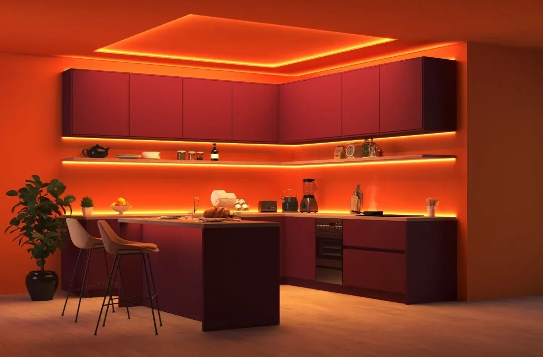 Eine Küche wird durch indirekte Philips Hue-Beleuchtung in orange-rotes Licht getaucht. 