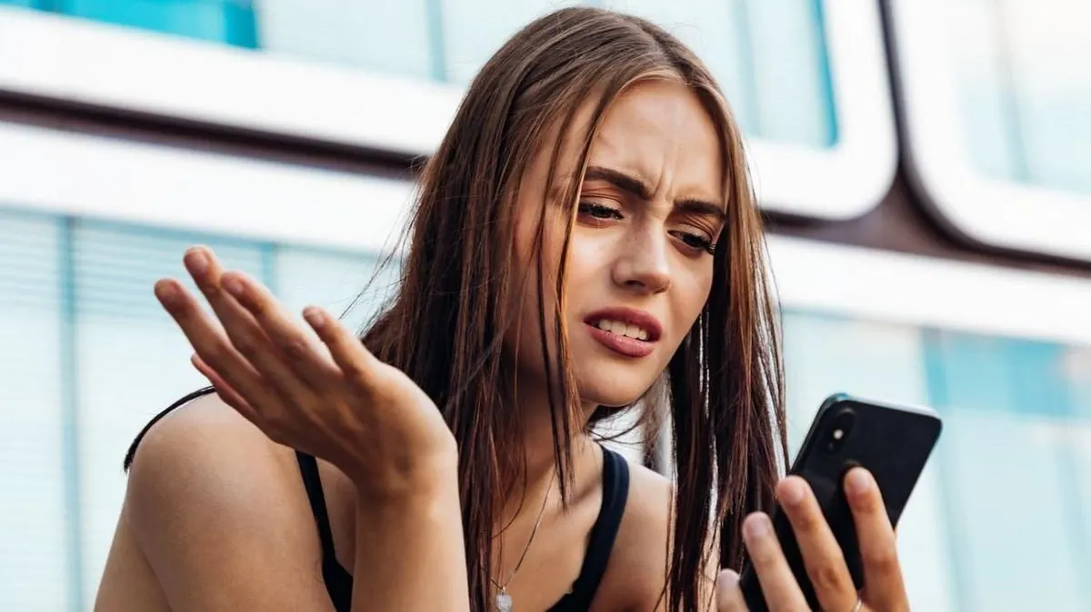 Frau schaut fragend auf ihr Smartphone