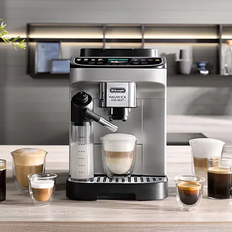 Eine silberne Delonghi-Kaffeemaschine steht auf einer Theke, umgeben von verschiedenen Gläsern mit Kaffeegetränken.