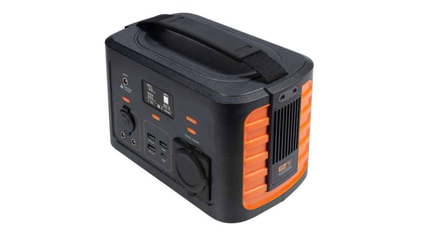 Schwarzes Kraftwerk mit Tragegriff und orangefarbenen Akzenten auf weißem Hintergrund. Mehrere Anschlüsse sind sichtbar.