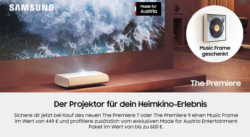 Ein heller Projektor auf einem Holzregal vor einer Leinwand mit Wellen. Ein Music Frame ist an der Wand.