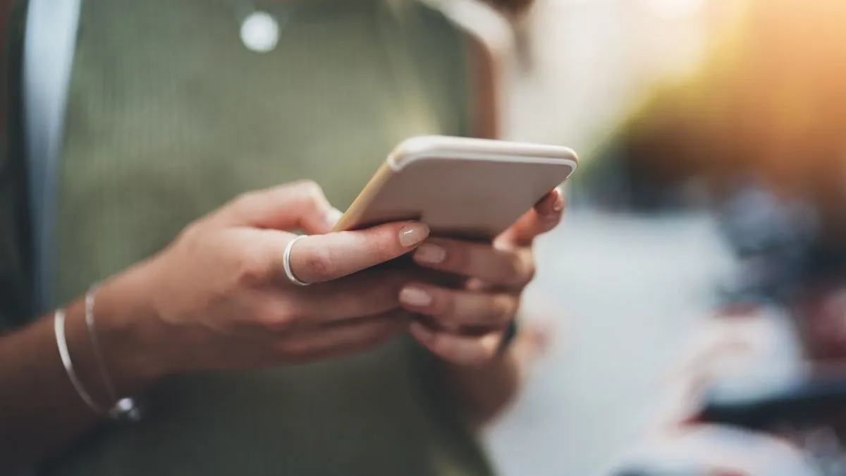 Person haelt ein Smartphone in der Hand