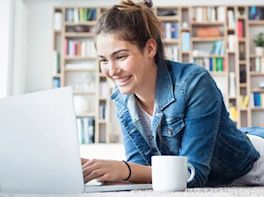 Frau sitzt vor Laptop.