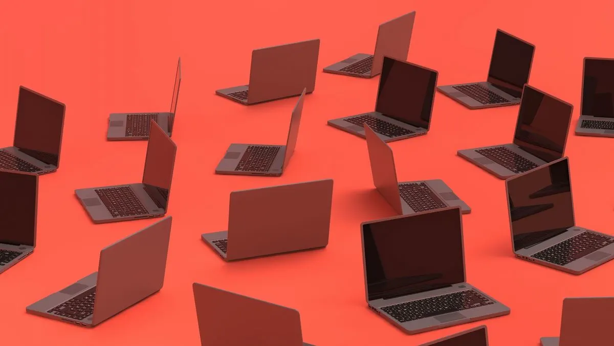 Viele aufgeklappte Laptops stehen verteilt auf rotem Untergrund.
