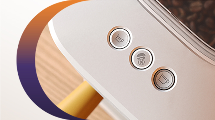  Detailansicht einer Kaffeemaschine mit drei beleuchteten Bedientasten für Kaffeezubereitung und Einstellungen neben dem Bohnenbehälter.