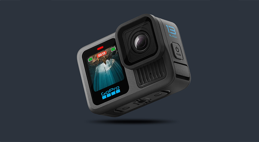 Eine schwarze GoPro-Kamera ist vor einem dunkelgrauen Hintergrund zu sehen. Auf dem Display ist eine Unterwasseraufnahme zu sehen.