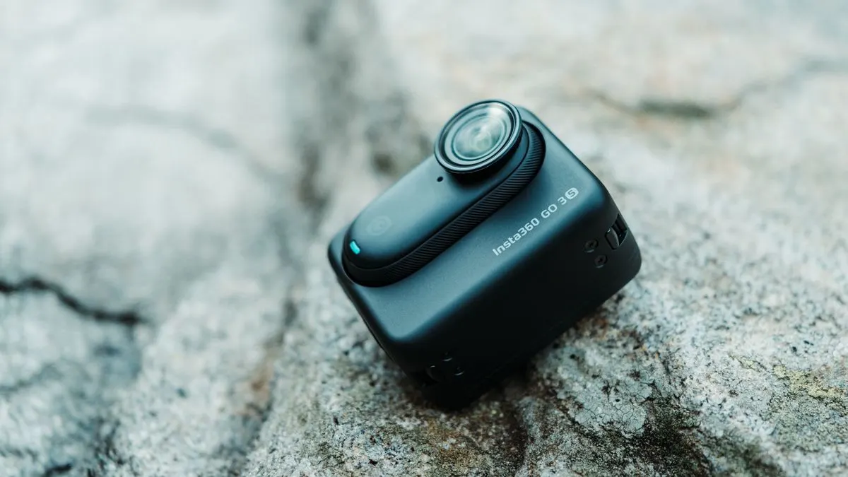 Schwarze Actionkamera Insta360 GO 3S liegt auf einem grauen Stein.
