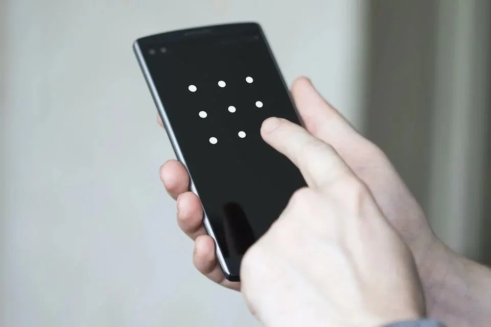 Smartphone auf dem gerade ein Sperrmuster eingegeben wird.