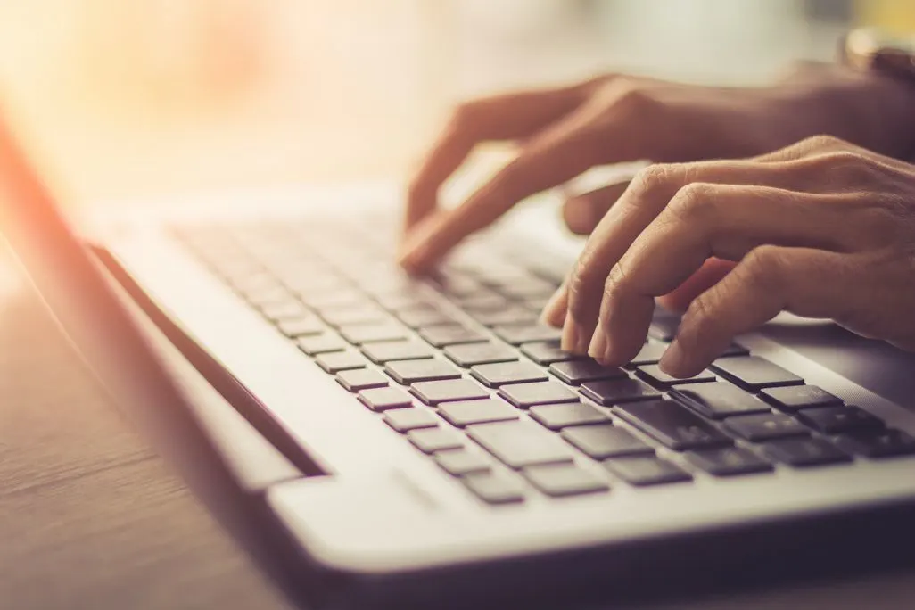 Haende tippen auf einer Laptop-Tastatur
