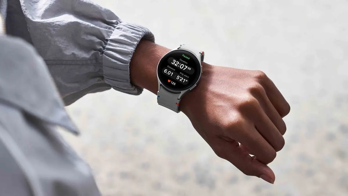 Person traegt eine Smartwatch mit hellem Armband und betrachtet Fitnessdaten