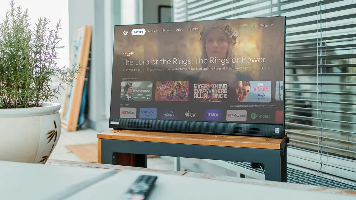 Ein Peaq Fernseher zeigt verschiedene Streamingdienste und eine Serienauswahl im Wohnzimmer.