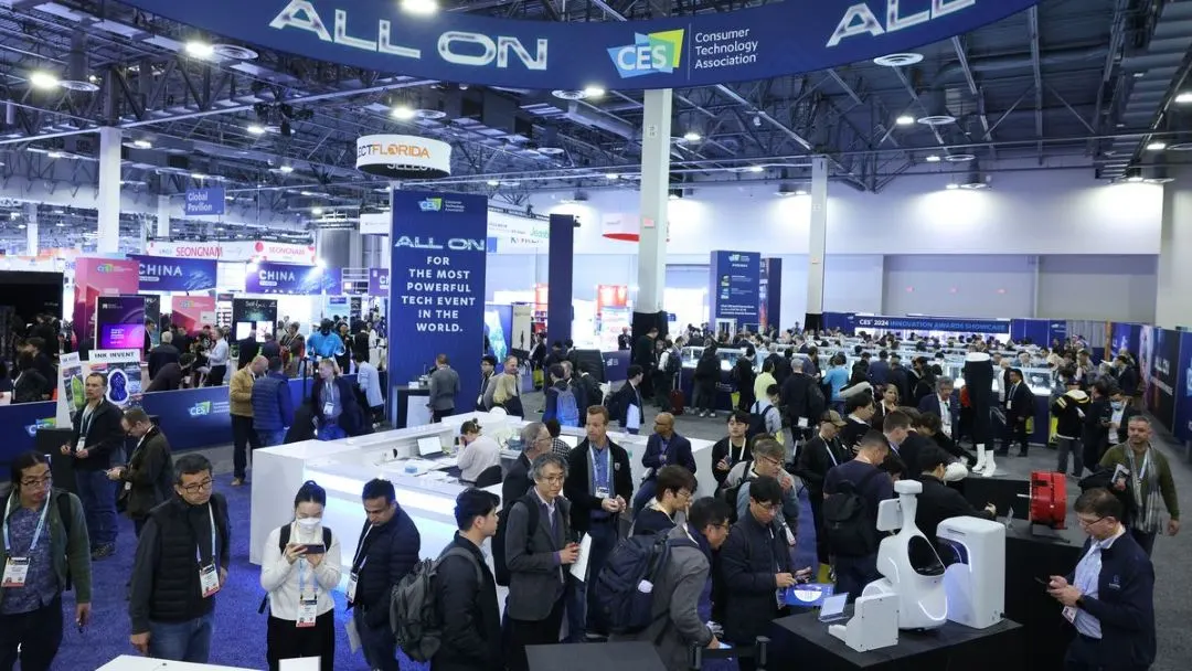 Grosse Technikmesse mit vielen Besuchern und Messestaenden unter dem Schriftzug CES