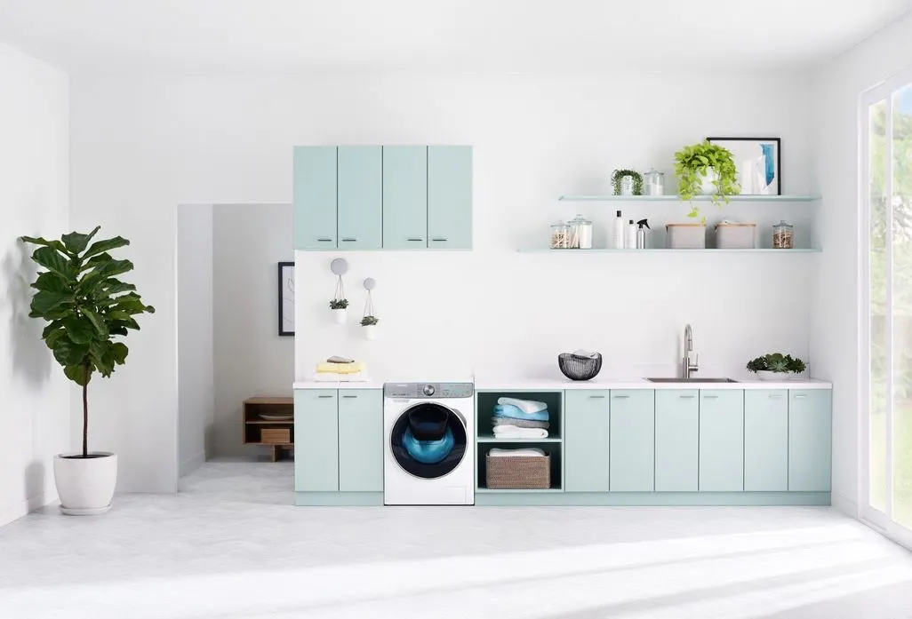 Moderne Waschküche mit mintfarbenen Schränken und integrierter Waschmaschine