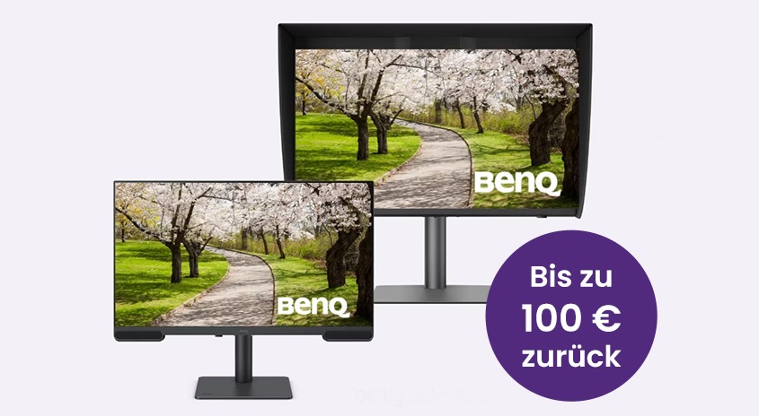 Zwei BenQ Monitore in unterschiedlichen Größen auf schwarzen Standfüßen, beide zeigen das gleiche Landschaftsbild mit blühenden Kirschbäumen und einem gewundenen Weg durch einen grünen Park. Rechts im Bild ein violetter Kreis mit weißer Schrift 'Bis zu 100 € zurück'. Das BenQ Logo ist auf beiden Bildschirmen sichtbar