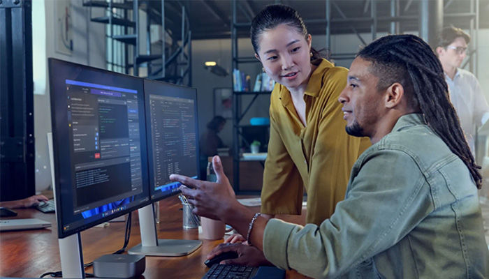 2 Menschen arbeiten in einem Büro mit HP Monitoren