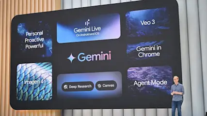 Eine Person steht auf einer Bühne vor einer großen digitalen Präsentationswand, auf der verschiedene Begriffe und Produkte rund um Googles AI "Gemini" angezeigt werden.