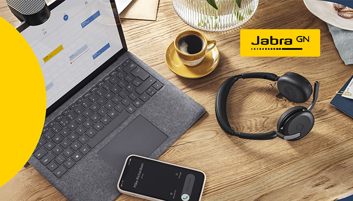 Auf einem Tisch befindet sich ein Notebook, ein Smartphone und ein kabelloses Headset. Rechts oben ist das Jabra Logo.