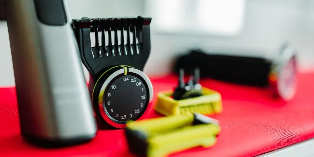 Nahaufnahme des Philips OneBlade Pro mit Zubehör für Längeneinstellung und Klinge im Fokus.