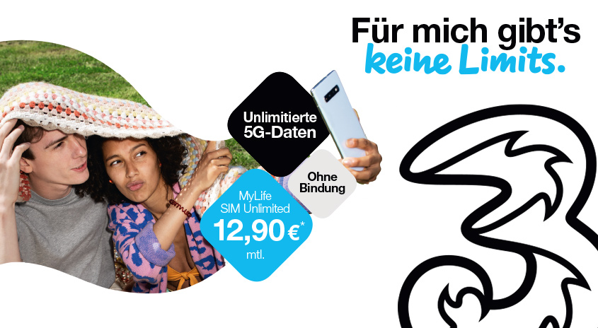 Zwei Personen unter Decke, Mobiltelefon in Hand. Werbung mit "Unlimitierte 5G-Daten" und Preisangabe 12,90€/Monat. Logo von Drei.