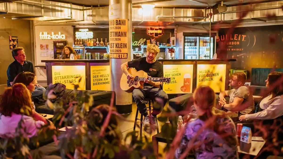 Samu Haber spielt Gitarre in einer Bar waehrend mehrere Gaeste zuschauen