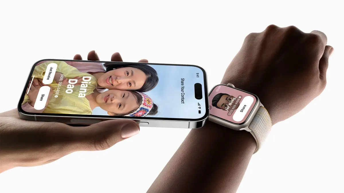 Person hält ein iPhone mit Kontaktübertragung neben eine Apple Watch am Handgelenk.