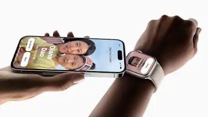 Person hält ein iPhone mit Kontaktübertragung neben eine Apple Watch am Handgelenk.