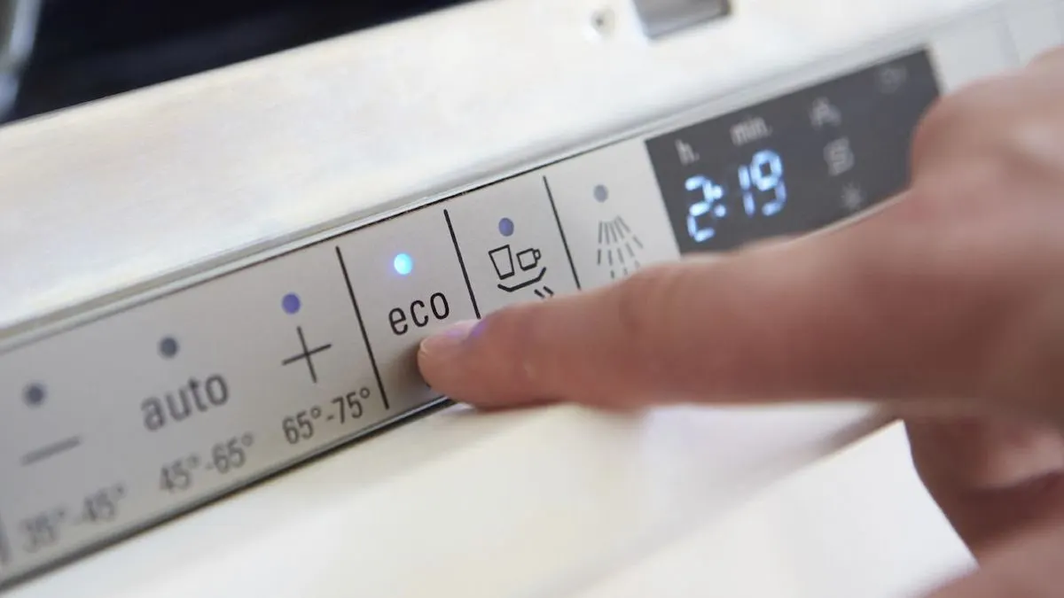 Finger drückt Eco-Taste auf Geschirrspüler-Bedienfeld. Blaue Leuchte über "eco" an, Digitalanzeige zeigt 2:19.